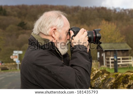 senior man using camera outdoors