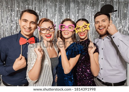 celebration, fun and holiday concept - happy friends posing with party props