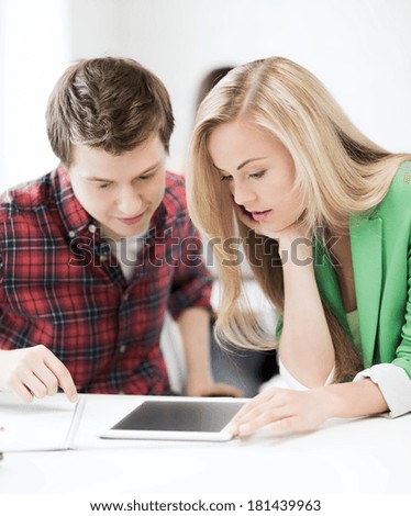 education concept - picture of students looking at tablet pc at school