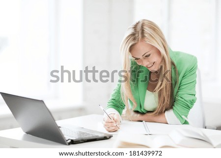 education concept - picture of smiling student girl writing in notebook
