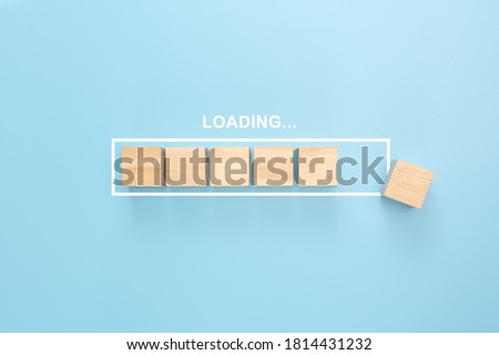 Showing loading bar with wood cube on blue background. Wooden blocks with the word LOADING in loading bar progress. Concept loading. Royalty-Free Stock Photo #1814431232