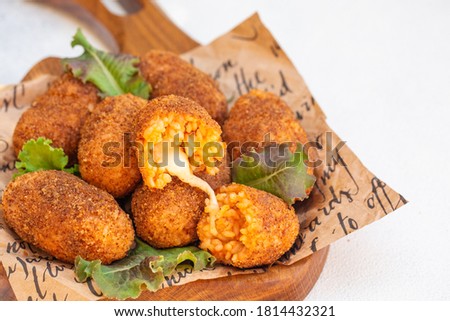 Rice balls stuffed with mozzarella cheese and deep fried. Close up. Copy space. Royalty-Free Stock Photo #1814432321