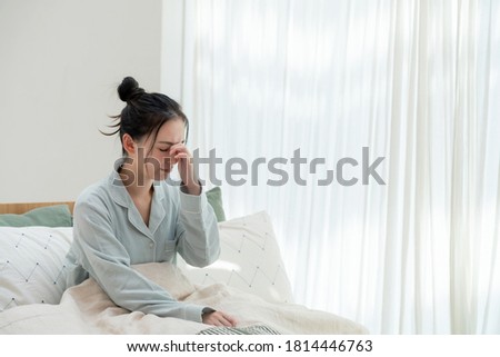 Depressed young asian woman in bedroom. Royalty-Free Stock Photo #1814446763