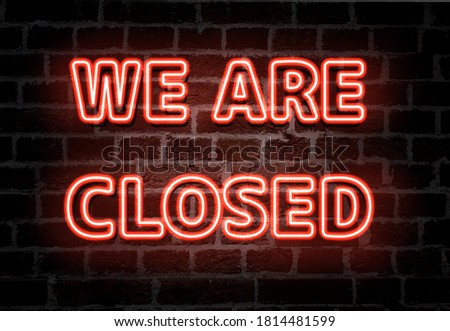 We are closed  red neon light entrance sign on brick wall