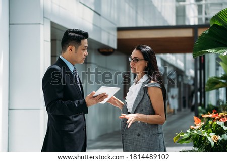 Team of professional employees discussing ideas on new project using digital tablet together stock photo