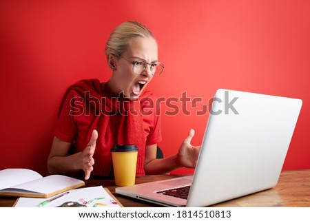 disgruntled woman look at laptop, dissatisfied with result on work. angry female feel herself unhappy, isolated red background