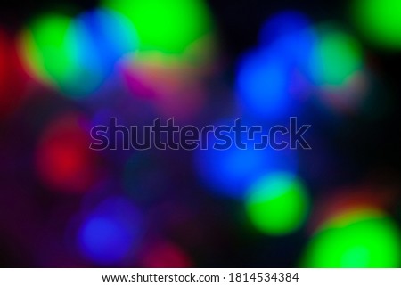 Red, green, pink, blue, blurry christmas and holiday lights in the dark. Multicolored, bright blurred bokeh background