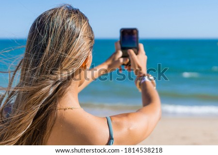 woman bikini on taking a picture with a smartphone