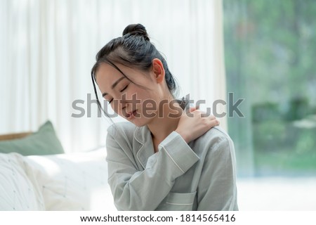 Depressed young asian woman in bedroom. Royalty-Free Stock Photo #1814565416