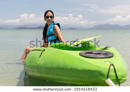 Tourist woman sitting on kayak enjoying beautiful island on vacation
