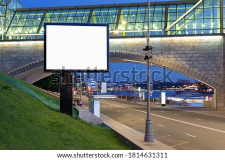 Big billboard at the modern footbridge in the evening.