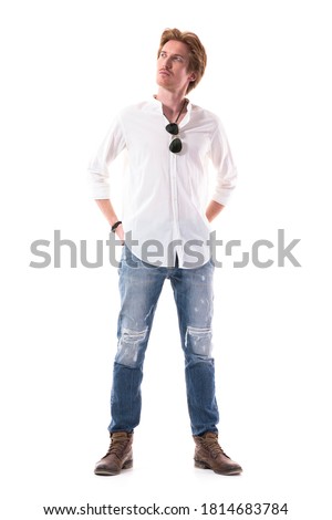 Thinking young stylish man looking up planning mindful with hands behind back. Full body length isolated on white background. 