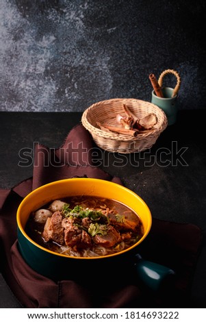 Braised pork noodles in a ceramic cup, black tone picture