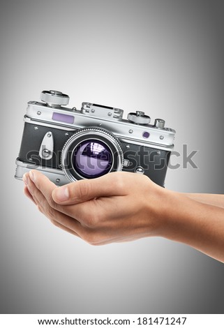 Man hand holding object ( Vintage silver photo camera ) High resolution 