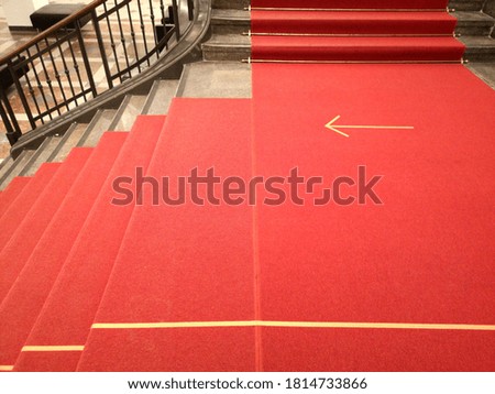 A high angle shot of a red stairway with the direction marked on the ground