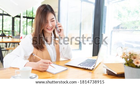 Woman using mock up smartphone while working with mock up digital tablet in office.