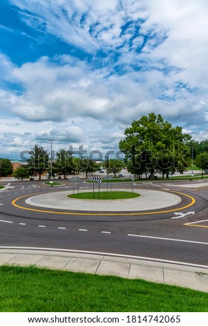 Vertical shot of a traffic roundabout with a blue cloudy sky.