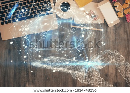Social network hologram drawings over computer on the desktop background. Top view. Double exposure.