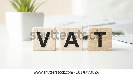 Vat on wooden cubes over blur background with copy spcae, financial concept background Royalty-Free Stock Photo #1814793026