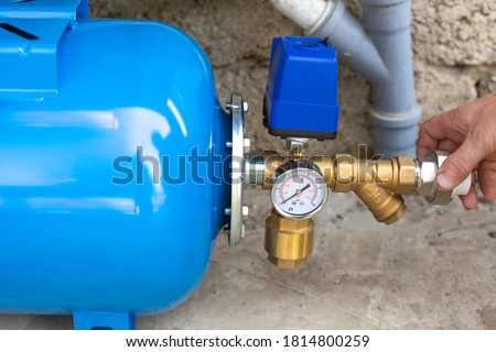 installation of a water supply station to a residential building using a hydraulic accumulator. Pumping station. Royalty-Free Stock Photo #1814800259
