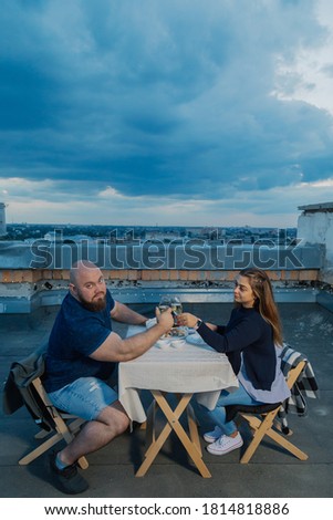Lovers on the roof sit at a table.