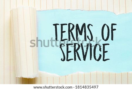 The text TERMS OF SERVICE appearing behind torn white paper