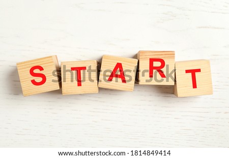 Word START made with wooden cubes on white background, flat lay