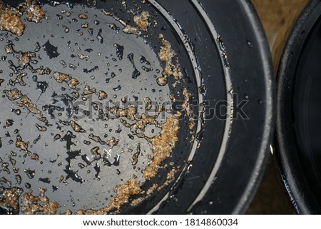 A closeup shot of a black plastic pan for gold panning