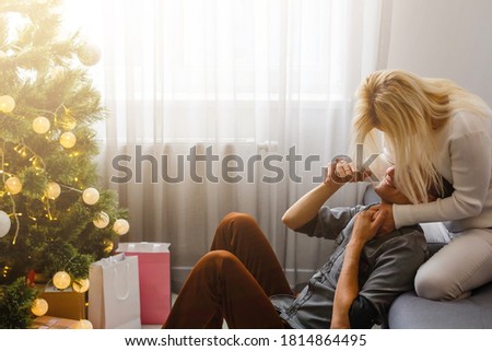 Couple Exchanging Christmas Gifts near Christmas tree.
