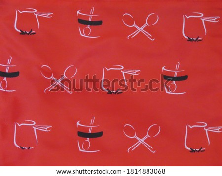White-black icons on a background of red fabric close-up (sports, gifts, food).