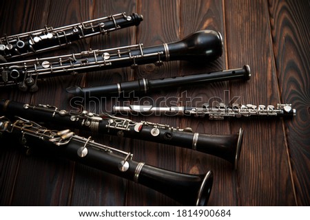 Woodwind instruments lie on a wooden surface Royalty-Free Stock Photo #1814900684