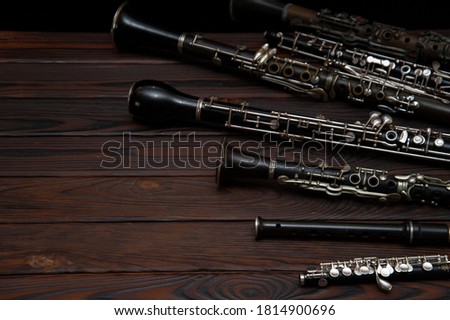 Woodwind instruments lie on a wooden surface Royalty-Free Stock Photo #1814900696