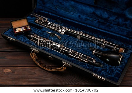 English horn or oboe in a case with reeds for playing on a wooden surface Royalty-Free Stock Photo #1814900702