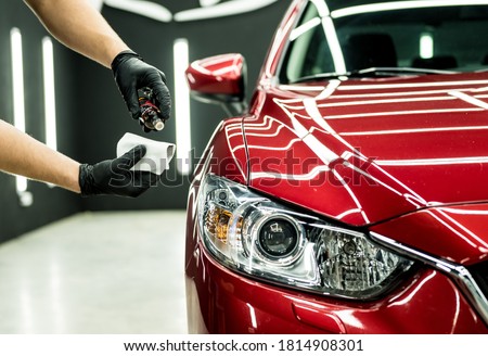 Car service worker applying nano coating on a car detail. Royalty-Free Stock Photo #1814908301