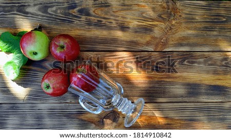 freshly picked apples in a transparent glass on a wooden background. apple juice or cider concept