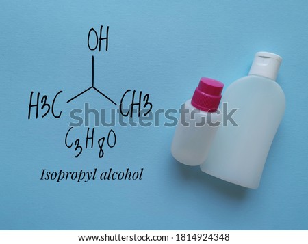 Structural chemical formula of isopropyl alcohol (2-propanol) with disinfectant or sanitizer in plastic packaging. Isopropanol is used as a rubbing-alcohol antiseptic, hand sanitizer, cleanser, etc. Royalty-Free Stock Photo #1814924348