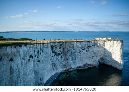 Old Harry Rocks chalk formations, view at Handfast Point, Dorset, southern England. Huge wall of white chalk cliffs with stumps and caves, tourist destination coastal view by the sea in south UK