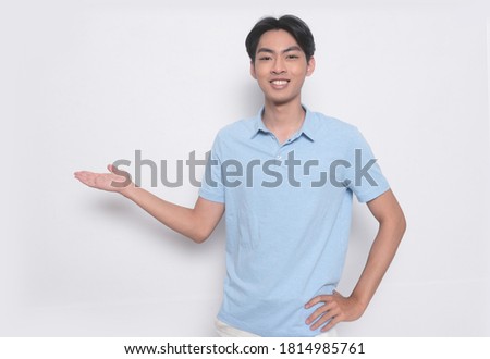 fashionable young man wearing  blue polo shirt with welcome gesture