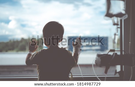 Toddler boy in intensive care unit or icu.Covid19 coronavirus. toddler boy wearing IV tube looking out window in hospital.Sick patient child baby boy in icu.Cancer, Pediatric, Dengue fever.monkeypox. Royalty-Free Stock Photo #1814987729
