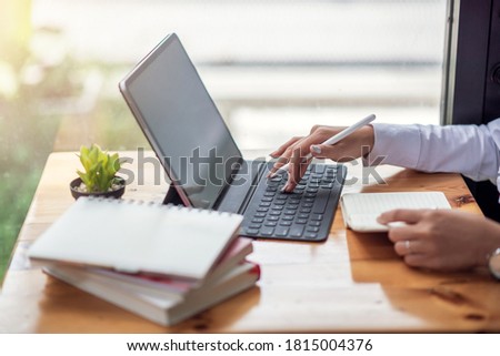 Mock up. Image of woman working with tablet with blank white screen in office.