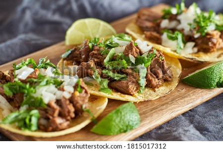 three carne asada mexican street tacos in corn tortilla with lime