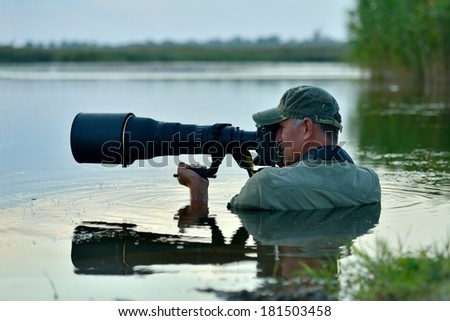 wildlife photographer outdoor, standing in the water Royalty-Free Stock Photo #181503458