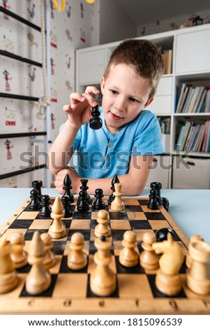 little serious boy plays chess, Little clever boy concentrated and thinking with chess
