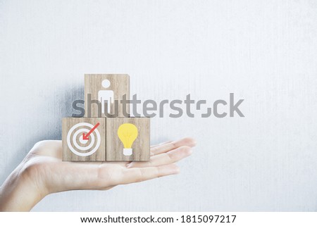 Hand holding business sign on wooden cubes on white wall background. Success and startup concept.