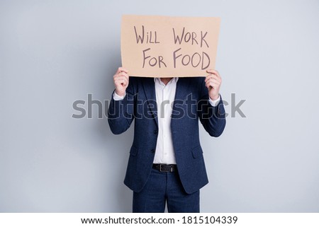 Will work for food. Photo of worker dismissed guy suffer victim financial crisis lost work hold placard search work food exchange hide face expression wear blue suit isolated grey background