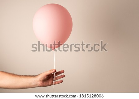 Air balloon in hand. Pink air balloon in a man's hand. Balloon for the holiday.