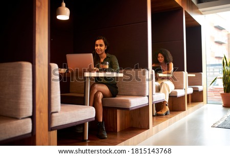 Businesswomen Working In Socially Distanced Cubicles In Modern Office During Health Pandemic Royalty-Free Stock Photo #1815143768