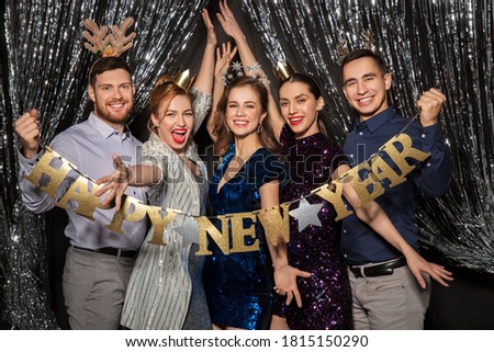 celebration and holiday concept - happy friends posing with happy new year banner Royalty-Free Stock Photo #1815150290