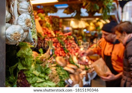 Vendor selling fruits and vegetables at his market stand at the Atarazanas market hall in Malaga, Spain