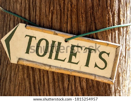 Toilet sign hanging on the tree